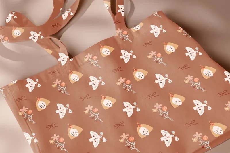 Close-up of a tote bag printed with a bird character pattern in terracotta